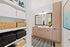 Luxurious bathroom featuring sleek wooden cabinetry, elegant lighting, and open shelves with neatly arranged towels and wicker baskets.