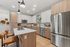 Modern kitchen with sleek stainless steel appliances, a spacious island with seating, and stylish wood cabinetry.