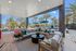 Elegant outdoor patio featuring a cozy seating area with plush cushions, surrounded by lush landscaping and shaded by chic blue umbrellas.