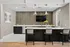 Chic modern kitchen featuring a sleek island with seating, elegant pendant lighting, and a stylish backsplash, perfect for entertaining.