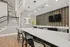 Modern kitchen with sleek white countertops, a stylish backsplash, and elegant pendant lighting in an open, inviting layout.
