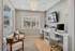 Inviting home office space with modern computers, plush seating, and a bright window view.