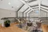 Elegant and spacious loft area with sleek modern furniture, vaulted ceilings, and large windows offering abundant natural light.