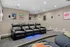 Luxurious home theater setup featuring sleek leather recliners with ambient blue lighting, surrounded by modern decor for ultimate comfort and style.