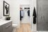 Elegant bathroom with modern vanity, stylish artwork, and spacious walk-in closet, featuring chic gray tiled shower.