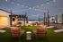 Enchanting rooftop patio with string lights, cozy seating, and mountain views, perfect for entertaining or relaxing under the stars.