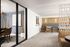 Modern apartment interior featuring a stylish lounge area with a plush gray bench, chic partition, and elegant decor.