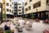 Chic apartment courtyard featuring stylish outdoor seating, lush greenery, and ambient string lights for a perfect urban retreat.