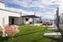 Luxurious rooftop terrace with mountain views, featuring stylish seating areas, lush artificial grass, and elegant string lighting.