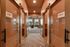 Inviting modern hallway with elegant sliding glass doors leading to a stylish and cozy seating area, featuring contemporary lighting and lush outdoor views.