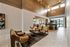 Elegant condominium common area featuring stylish lounge chairs, a chic coffee table, and modern lighting with large windows offering natural light and outdoor views.