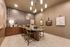 Chic and modern dining area featuring a round table with stylish chairs, accented by elegant pendant lighting and artistic wall decor.