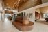 Luxurious apartment lobby with elegant lighting, modern wood accents, and artistic decor, creating a warm and inviting atmosphere.