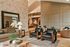 Elegant living room with modern decor, featuring a cozy seating area, stylish patterned walls, and warm lighting.