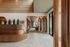 Elegant apartment lobby with modern wooden accents, lush indoor plants, and contemporary lighting creating an inviting atmosphere.