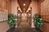 Chic hallway with elegant sliding doors, vibrant potted plants, and warm ambient lighting.