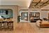 Modern open-concept living area with elegant arches, stylish seating, a chic dining table, and vibrant greenery, offering a welcoming ambiance.