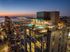 Ancora high-rise building with stunning rooftop pools and breathtaking city and waterfront views at sunset.