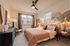 Inviting bedroom with stylish decor, featuring a cozy bed, elegant wallpaper, and chic lighting for a serene atmosphere.