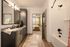 Modern bathroom with sleek black cabinetry, spacious vanity, polished fixtures, and a cozy view into the stylish bedroom.