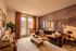 Elegant living room with artistic wallpaper, cozy brown sofa, and chic decor showcasing warm, inviting ambiance.