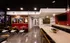 Chic apartment lounge with modern art, sleek red seating, and industrial lighting, perfect for stylish gatherings.