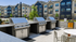 Modern apartment community with outdoor barbecue area featuring sleek stainless steel grills and stylish seating, perfect for social gatherings.