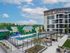 Modern apartment complex with vibrant mural backdrop, luxurious outdoor pool, and stylish patio area surrounded by lush greenery.