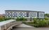 Modern multi-story apartment building with a sleek facade, landscaped surroundings, and convenient city access.