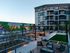 Modern apartment complex featuring a vibrant mural, luxurious outdoor seating, and inviting barbecue area with lush greenery.