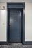 Elegant blue apartment door labeled '324', enhanced by a modern electronic lock and softly illuminated by wall-mounted spotlight, providing a welcoming ambiance.