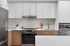 Modern kitchen with sleek stainless steel appliances, white cabinetry, and elegant subway tile backsplash.