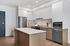 Modern kitchen with sleek white cabinetry, stainless steel appliances, and an elegant marble countertop island.