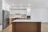 Modern kitchen with sleek stainless steel appliances, elegant white cabinetry, and a spacious wooden island perfect for culinary creativity.