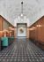 Elegant corridor with mid-century modern design, featuring sleek wood paneling, geometric tile flooring, and stylish lighting.