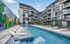 Modern apartment complex featuring a vibrant mural, large swimming pool, and ample outdoor seating for relaxation.