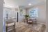 Bright and modern dining area featuring elegant decor, large windows, and a cozy seating arrangement.