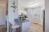 Bright, modern kitchen with sleek white cabinets, stainless steel appliances, and a cozy breakfast bar, perfect for intimate dining.