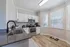 Bright and stylish kitchen with modern appliances, sleek cabinetry, and elegant wood flooring, offering ample natural light through large windows.