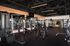 Modern fitness center featuring high-end gym equipment with bright lighting and spacious layout.