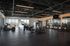 Modern and spacious gym with state-of-the-art equipment, large windows offering mountain views, and sleek black flooring.