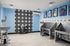Modern pet washing station with stainless steel tubs, paw print tiles, and vibrant pet artwork on a serene blue wall.
