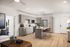 Modern kitchen with sleek grey cabinets, island with seating, and elegant decor in spacious apartment.