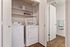 Modern laundry nook with washer, dryer, and stylish shelving in a bright, organized space.