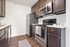 Modern kitchen with sleek dark cabinets, stainless steel appliances, and elegant white countertops.