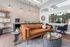 Modern living area featuring a stylish leather sofa, elegant wall decor, and a cozy coffee nook with lush greenery accents.