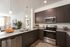 Contemporary kitchen with sleek dark wood cabinets, granite countertops, and stainless steel appliances opening into a cozy, light-filled living area.