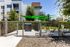 Charming apartment exterior with lush greenery and a well-maintained dog park enclosed by a stylish fence, ideal for pet lovers.