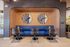 Chic modern seating area with sleek blue booth, stylish round tables, and contemporary wall art, perfect for a cozy gathering.