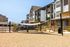 Modern apartment complex featuring stylish architecture with spacious balconies, natural stone accents, and a welcoming outdoor space ideal for relaxation.